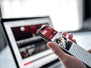 Ein Smartphone mit einem Laptop im Hintergrund
