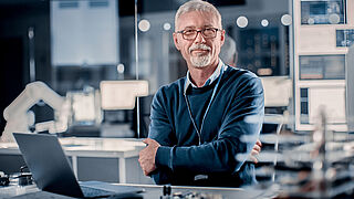 Bild eines Mannes mit seinem Laptop am Arbeitsplatz