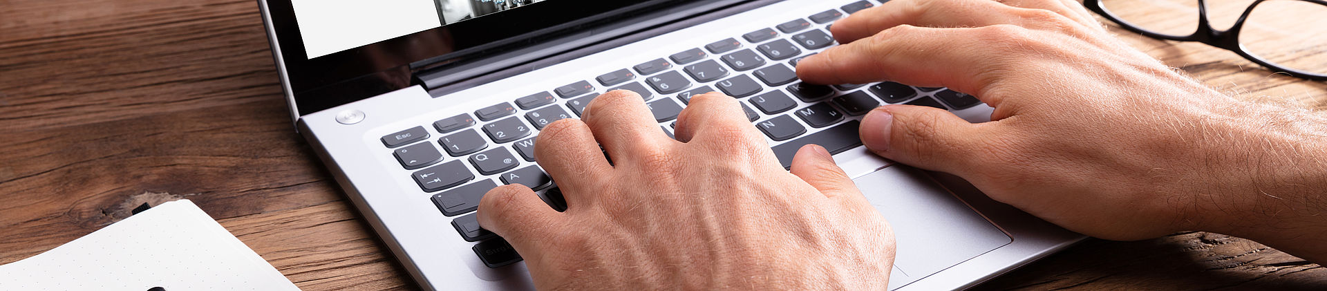 Hände auf einer Laptop-Tastatur